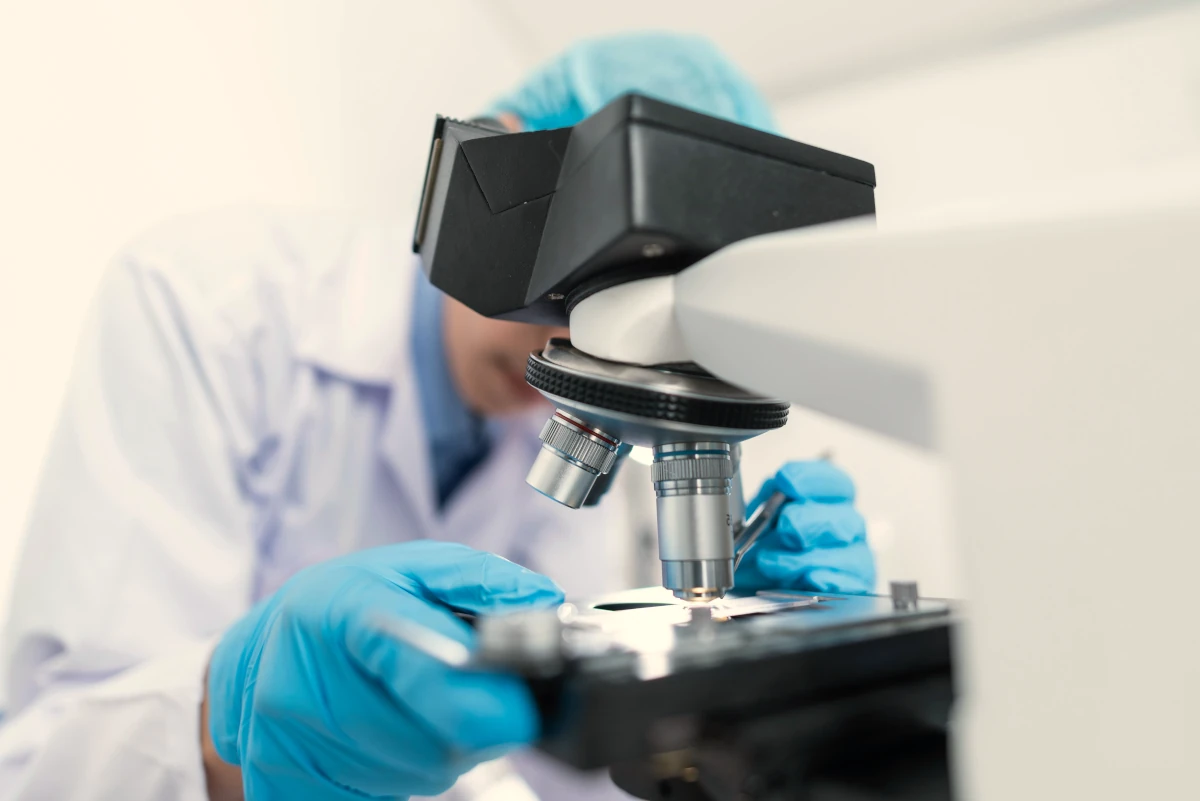 Científico utilizando un microscopio en un laboratorio relacionado con la medicina de precisión.